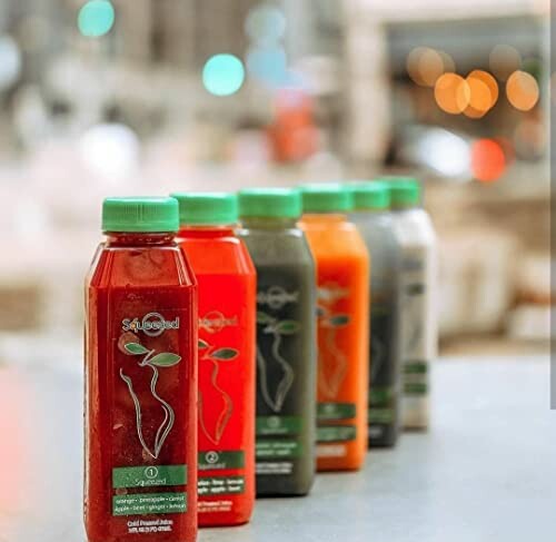 Assorted juice bottles lined up on a table.